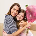 Mother receiving flower bouquet from her daughter
